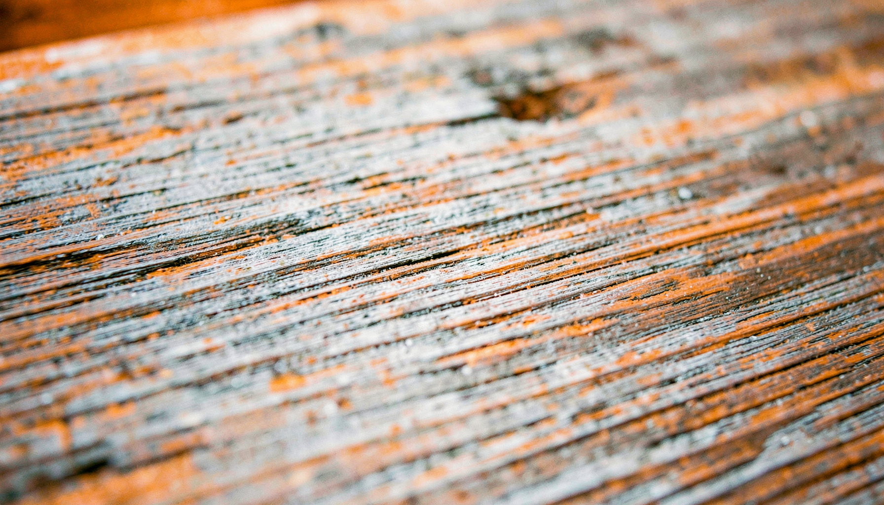 Close detail of reclaimed wood grain texture with subtle grey weathering, highlighting the natural aesthetic of composite materials.
